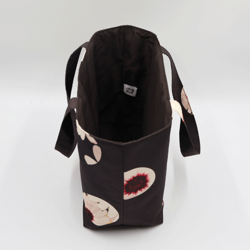 Medium teacher/book bag with white abstract daisy design on a black background. Without plastic inner.