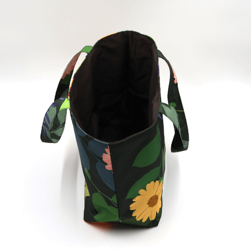 Medium teacher/book bag with bright, daisy design on a black background. Without plastic inner.