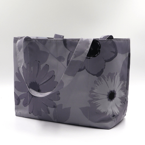 Medium teacher/book bag with floral daisy design in dark and light grey on a soft silver-grey background. Side angle.