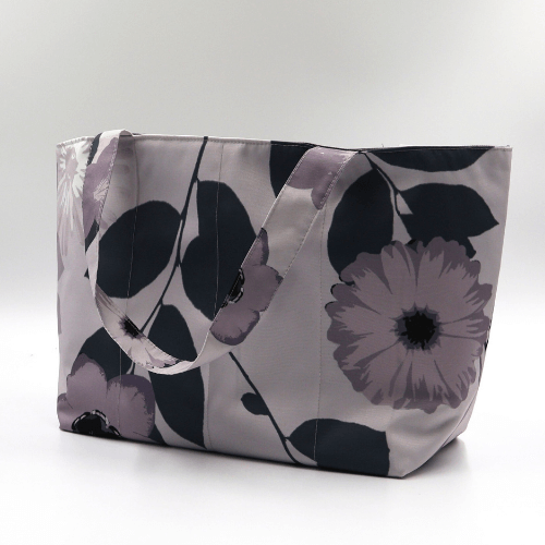 Medium teacher/book bag with floral daisy design in dark and light mauve on a soft mauve background. Side angle.