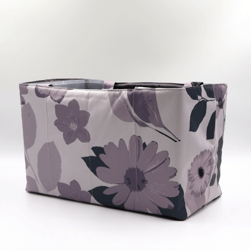 Large teacher/book bag with floral daisy design in dark and light mauve on a soft mauve background. Side view.