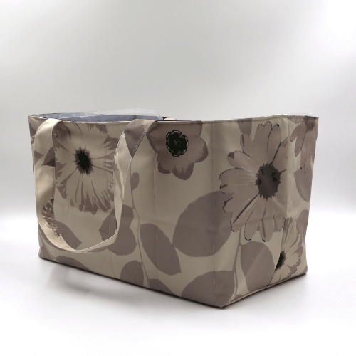 Large teacher/book bag with floral daisy design in dark and light beige and taupe. Side angle.