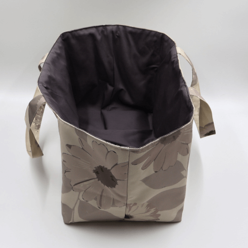 Large teacher/book bag with floral daisy design in dark and light beige and taupe. Without plastic inner.