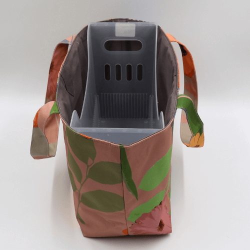 Medium teacher/book bag with bright floral daisy design on a dark peach background. With plastic inner.