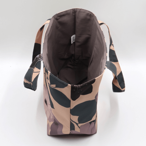 Medium teacher/book bag with daisy floral design in dark and light mauve on a dusky peach background. Without plastic inner.