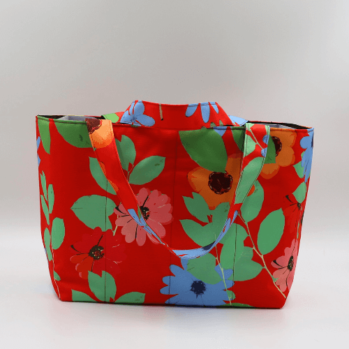 Medium teacher/book bag with bright daisy floral design on a red background. Carry books and crafts.