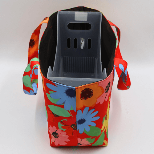 Medium teacher/book bag with bright daisy floral design on a red background. With plastic inner.