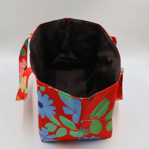Large teacher/book bag with bright daisy floral design on a red background. Without plastic inner.