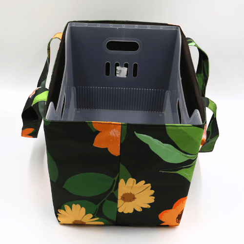 Large teacher/book bag with bright, daisy design on a black background. With plastic inner.