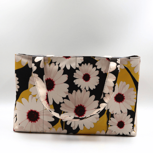Large teacher/book bag with white, daisy design on a black background. Carry books and crafts.