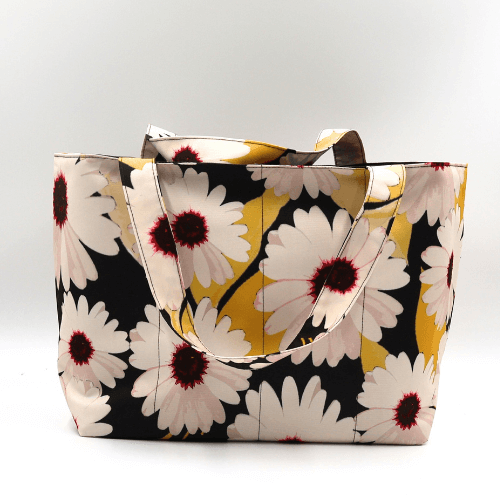 Medium teacher/book bag with white, daisy design on a black background. Carry books and crafts.