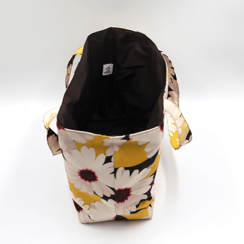 Medium teacher/book bag with white, daisy design on a black background. Without plastic inner.