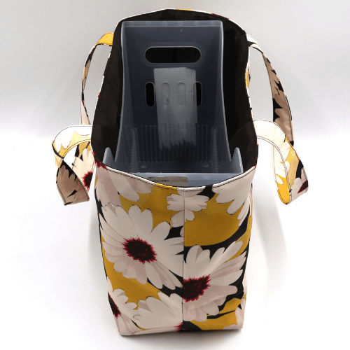 Medium teacher/book bag with white, daisy design on a black background. With plastic inner.