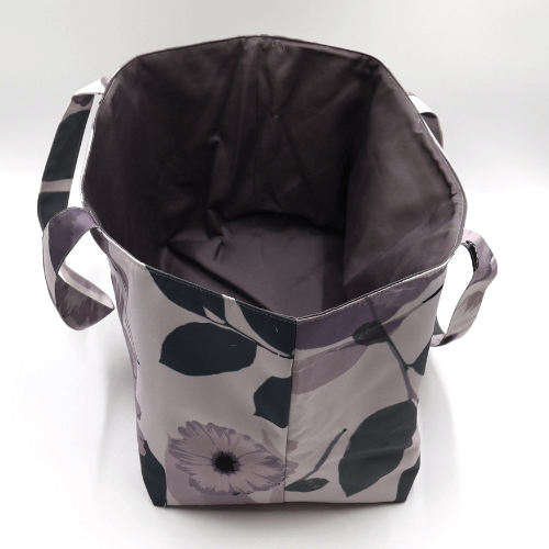Large teacher/book bag with floral daisy design in dark and light mauve on a soft mauve background. Without plastic inner.
