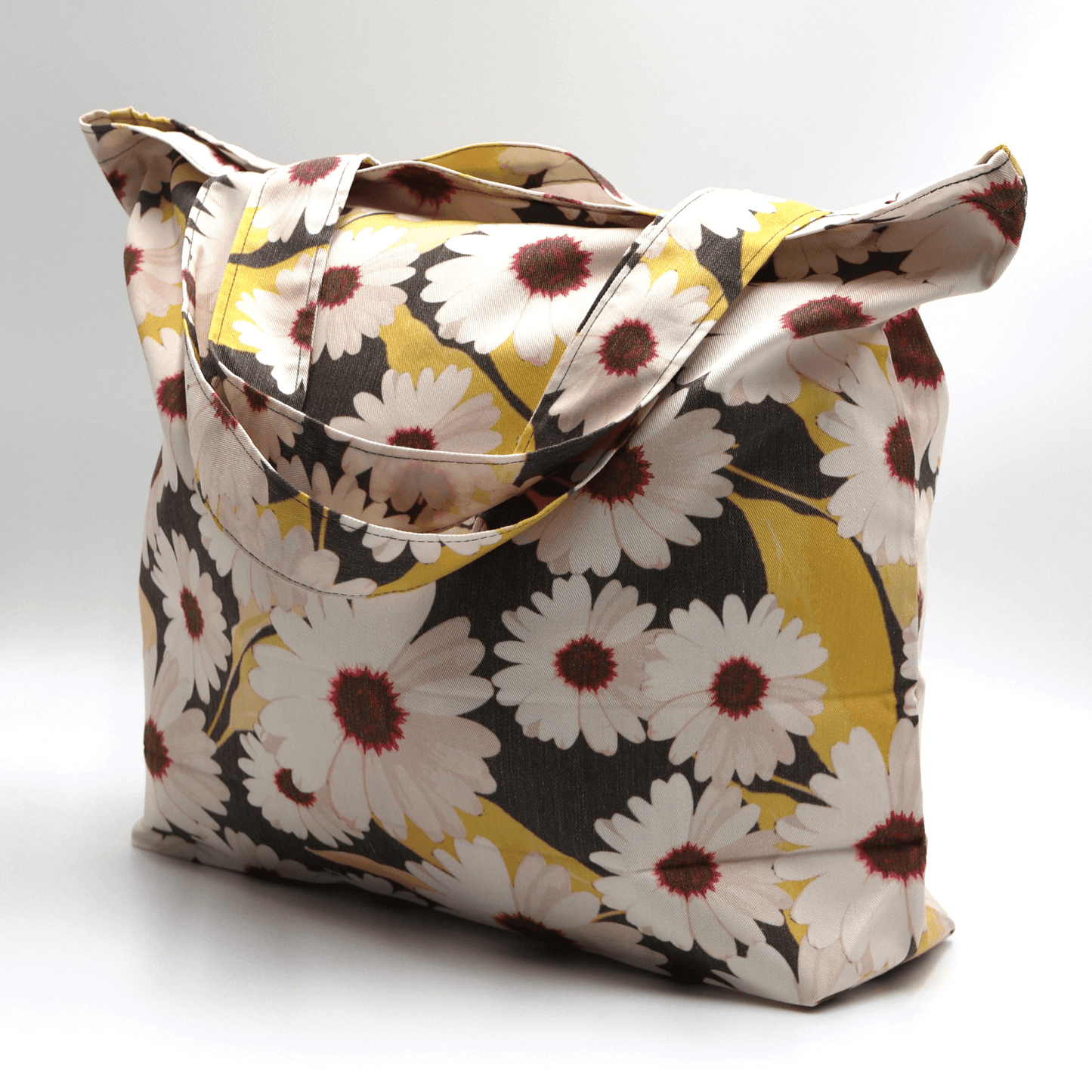A big, durable tote bag with a white Daisy design. Carry all your daily essentials, books or shopping.