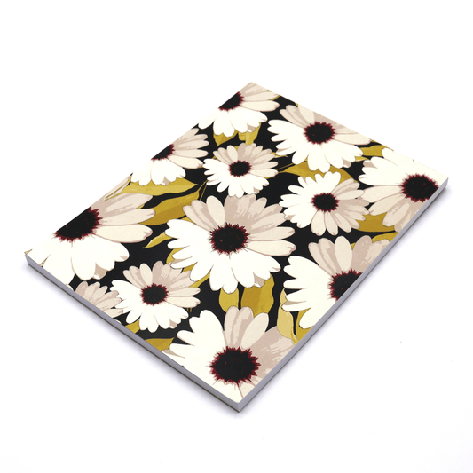 A4 sketchpad with white daisy floral design on a black background.