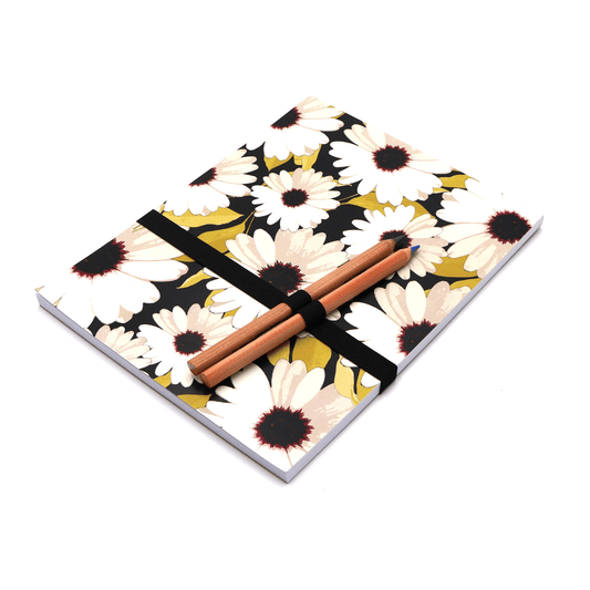 A4 sketchpad pencils and pencil holder with white daisy floral design on a black background.