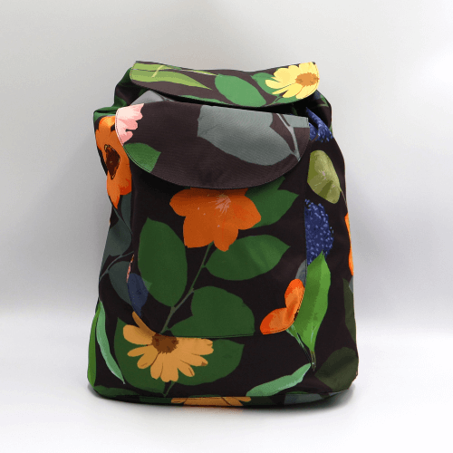 Lightweight backpack with drawstring and bright daisy floral design on dark brown/black background.