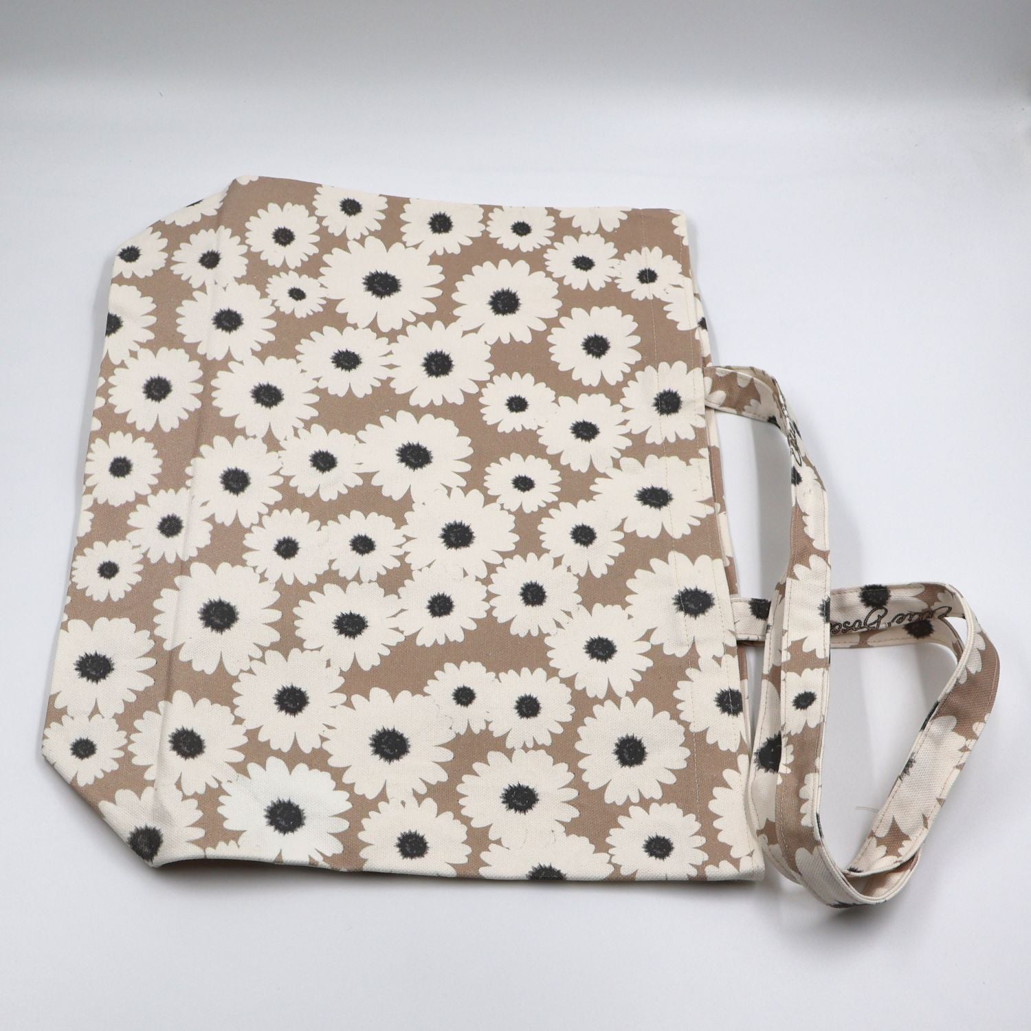 Flat lay view of Daisy Drift wildflower printed neutral canvas tote bag showing local print design