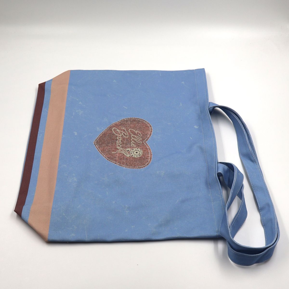 Flat lay view of a wide forty six centimeter by forty two centimeter blue cotton canvas shopper tote displaying the full heart pattern layout