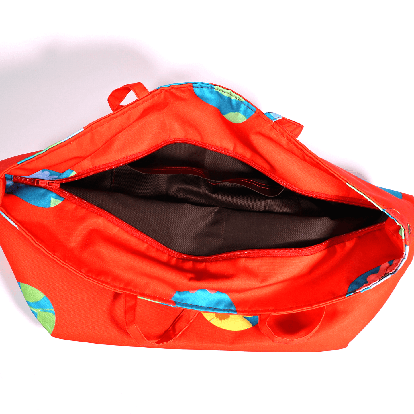 A bright red carryall bag with a stripe abstract floral design. Top view. Open.