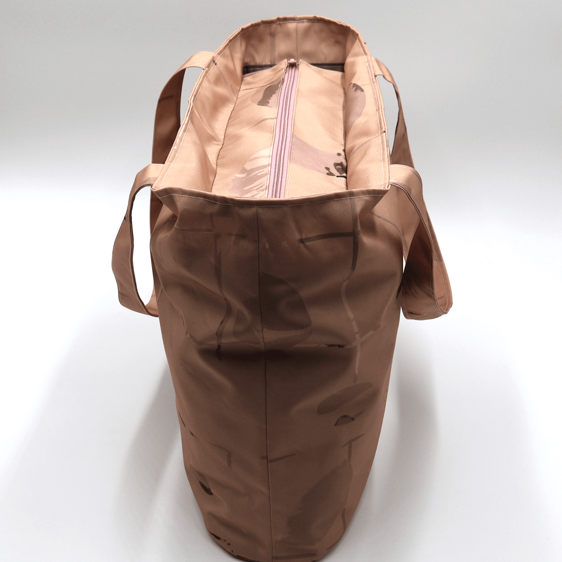 Shoulder bag with geometric/floral design in rusty orange and brown. Zipped closure. Top view.