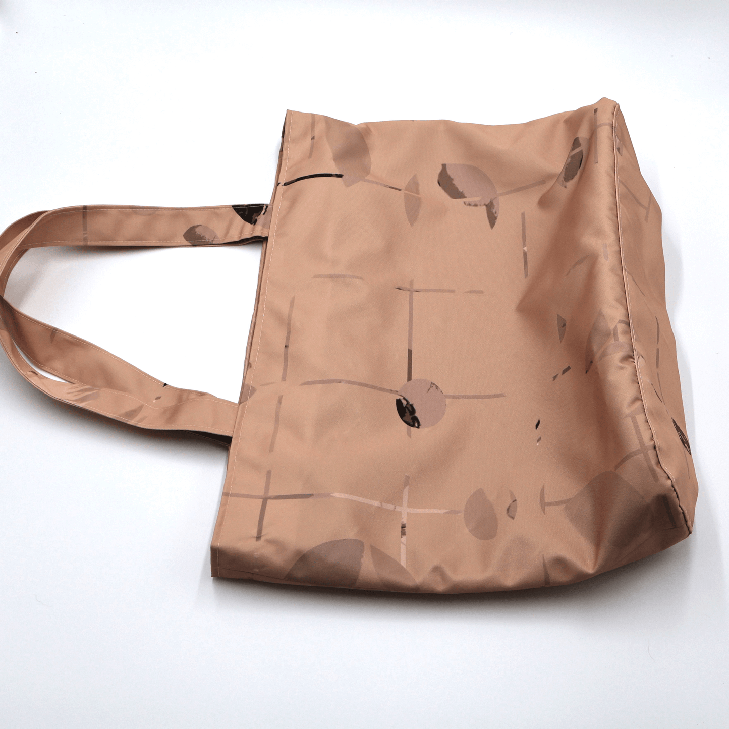 Shoulder bag with geometric/floral design in rusty orange and brown. Perfect for carrying books and documents. Flat view.