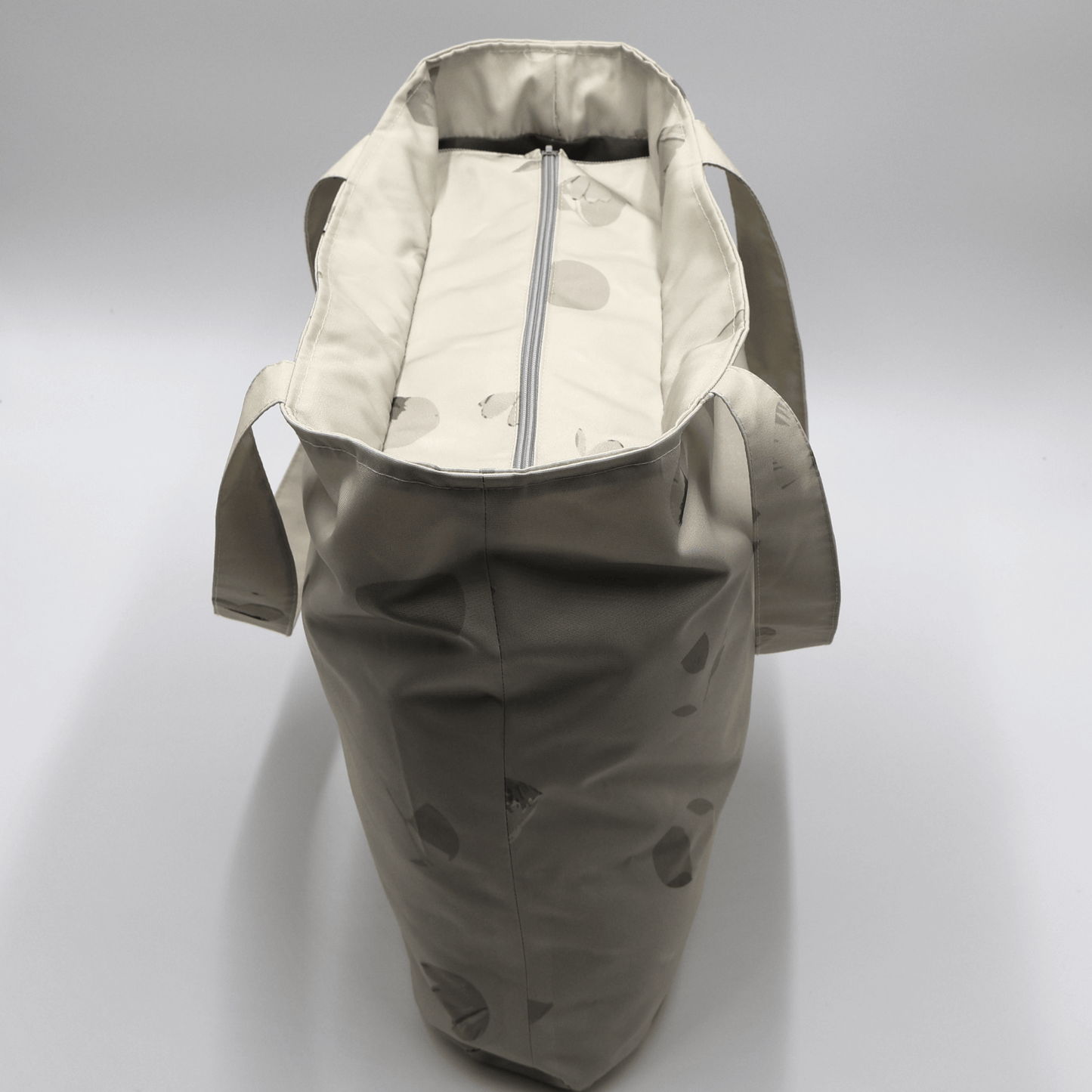 Shoulder bag with daisy floral design in beige, ivory and taupe. Zipped closure. Top view.
