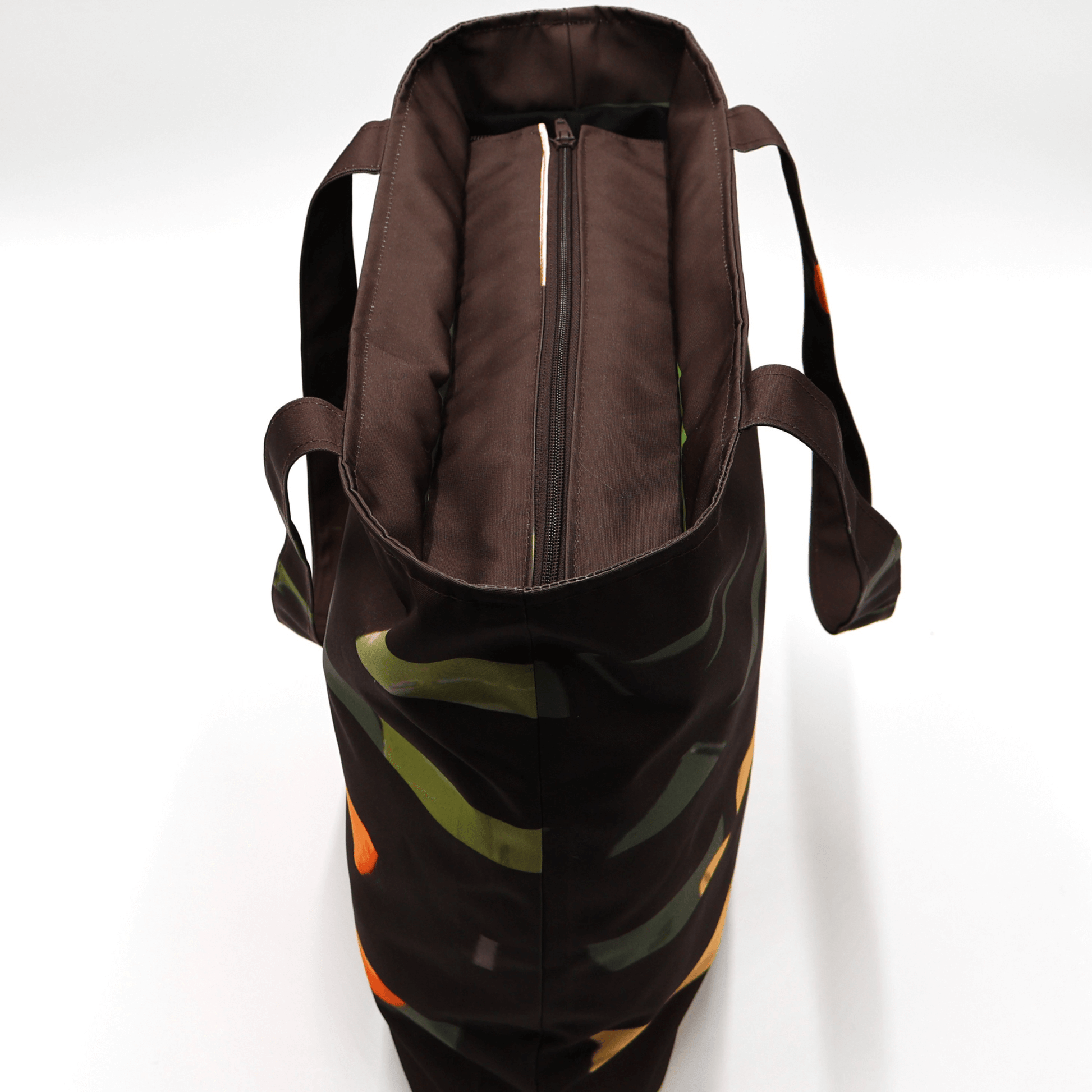 Shoulder bag with bright stripe/floral daisy design on a black background. Perfect for carrying books and documents. Top view.
