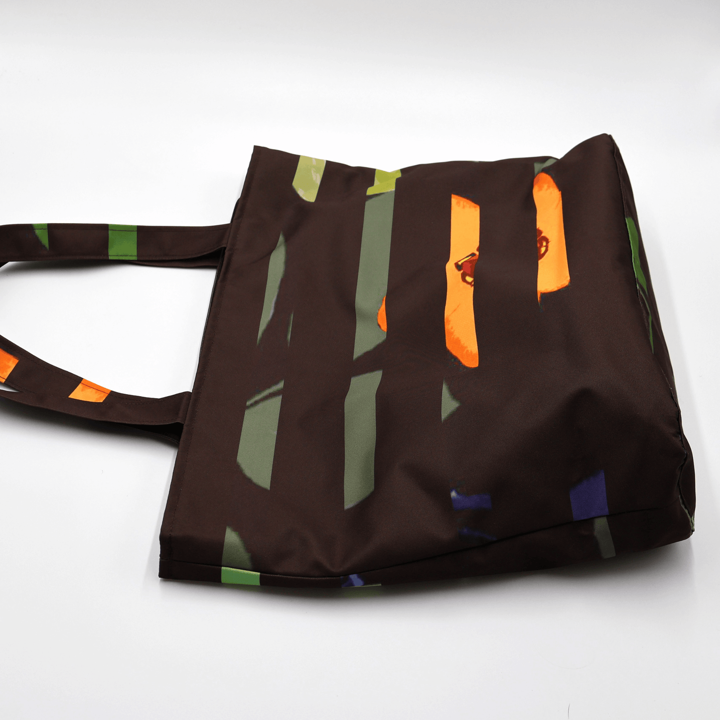 Shoulder bag with bright stripe/floral daisy design on a black background. Perfect for carrying books and documents. Flat view.