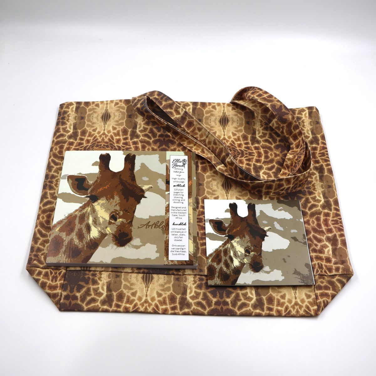 Individual wildlife stationery and lifestyle items shown separately flat lay style including a thick paper square twenty by twenty centimeter sketchpad a large cotton canvas shopper bag and card