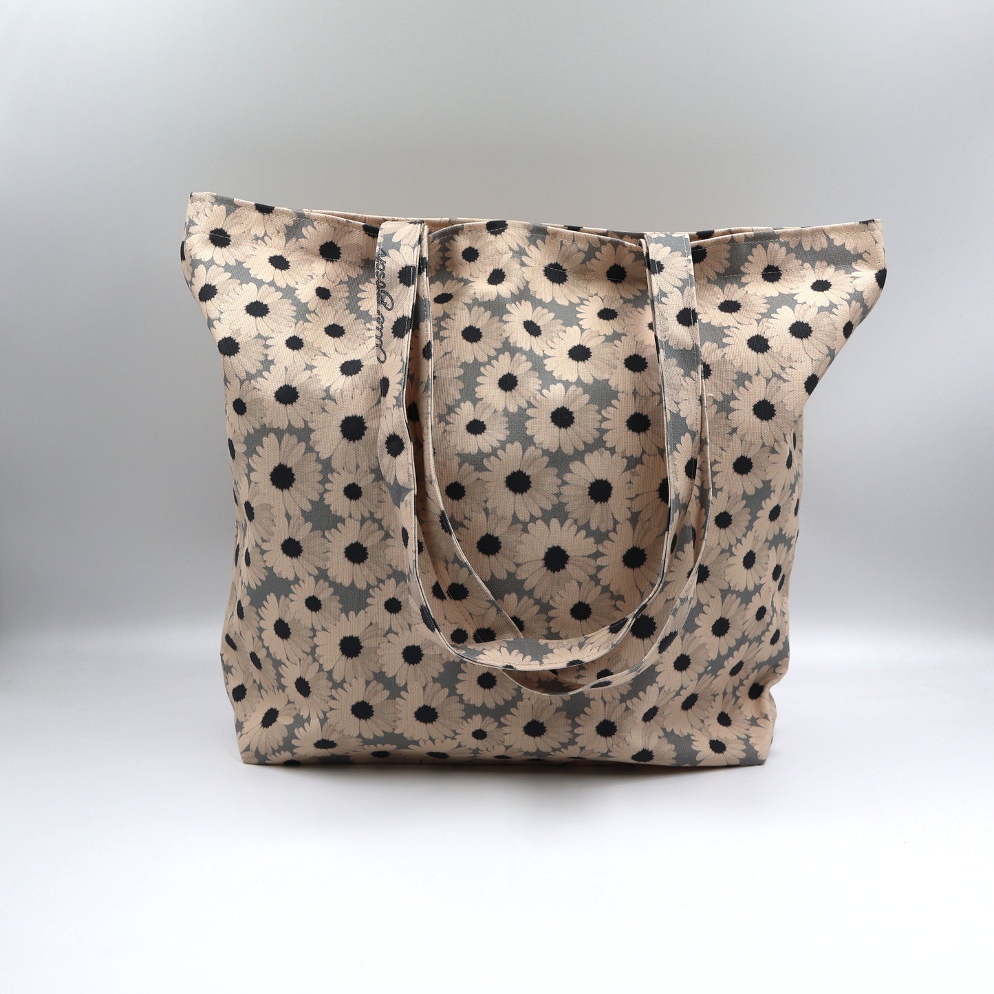 Close-up detail of the cheerful beige daisy print on the front panel of the ladies ocean slate grey canvas tote bag, highlighting the premium fabric texture.