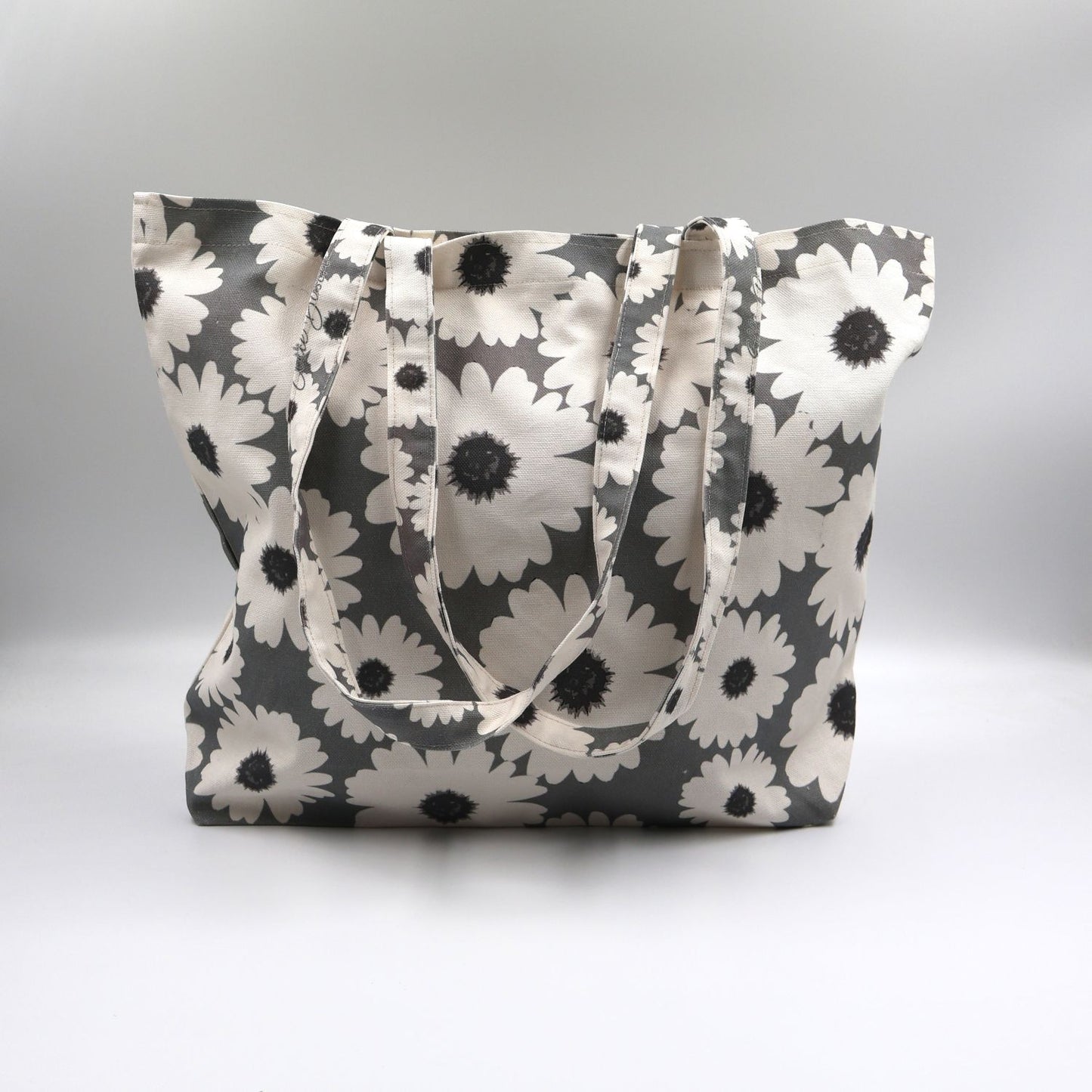 Close-up detail of the bold white wildflower print on the front panel of the ladies sea mist grey canvas tote bag, highlighting the premium fabric texture.