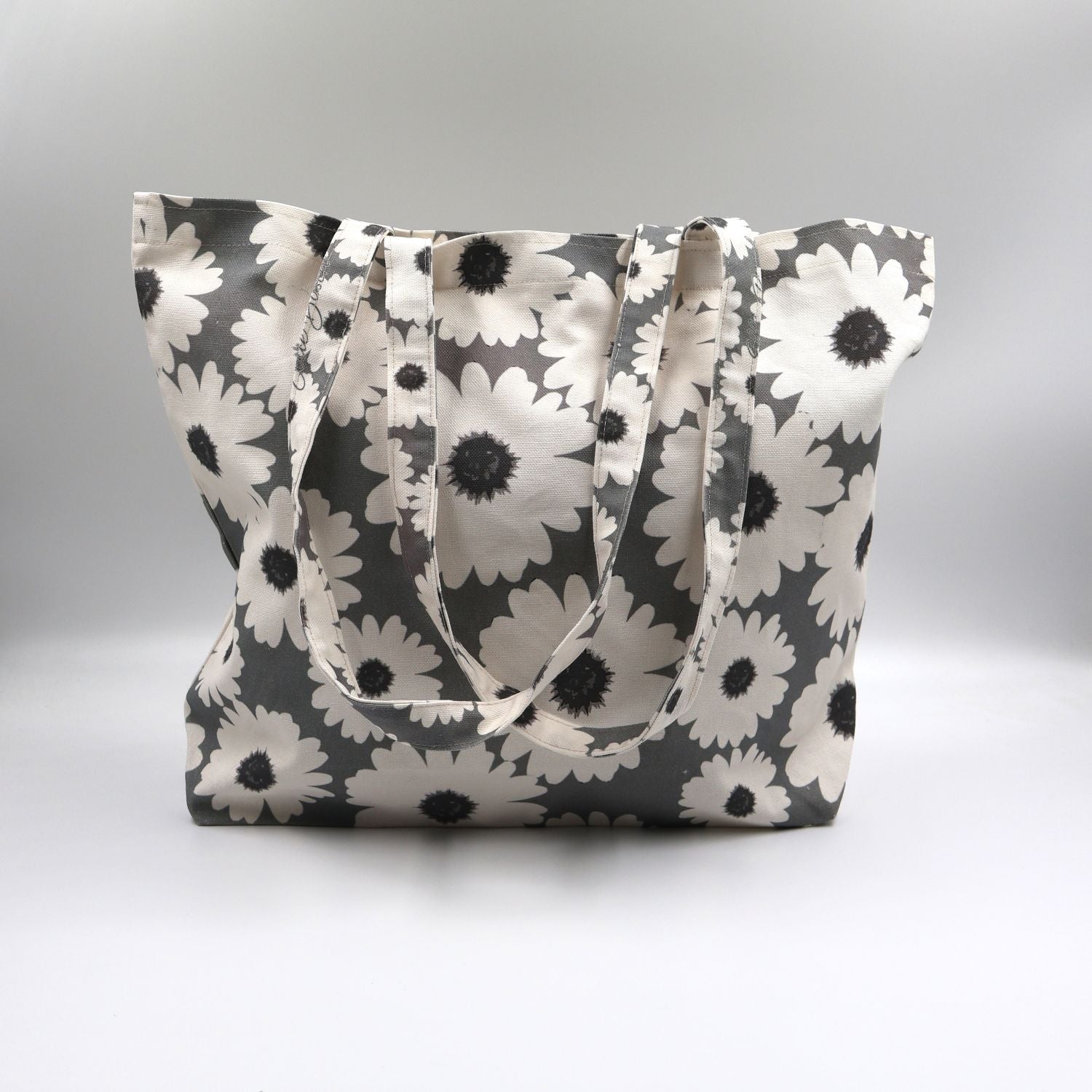 Close-up detail of the bold white wildflower print on the front panel of the ladies sea mist grey canvas tote bag, highlighting the premium fabric texture.
