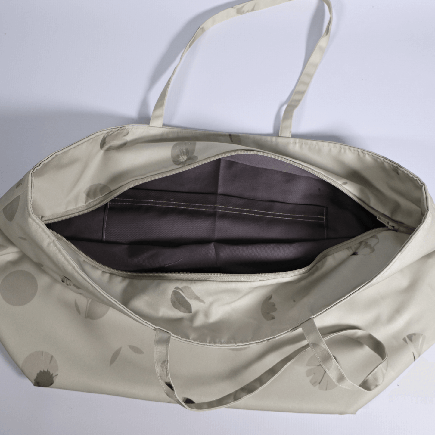 Secure top zip closure on a spacious beige canvas travel tote bag showing internal storage capacity for daily essentials.