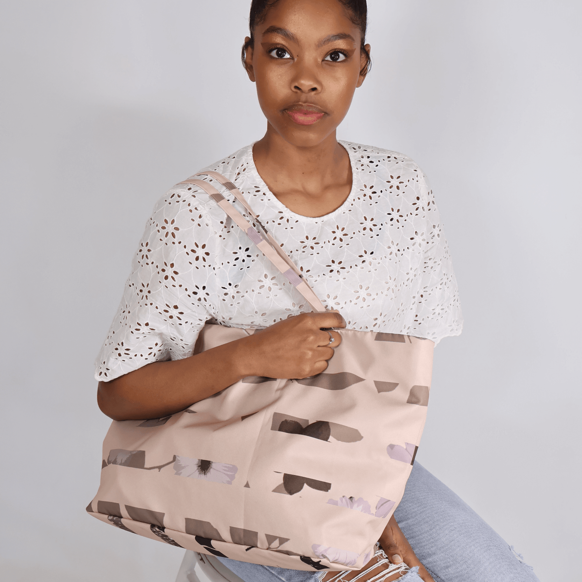 Model carrying a large canvas shoulder tote bag from the South African Stone Meadow collection for work or travel.