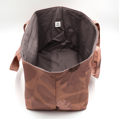 Wide spacious interior of a large orange canvas craft and teacher bag designed to hold file organizers and books.