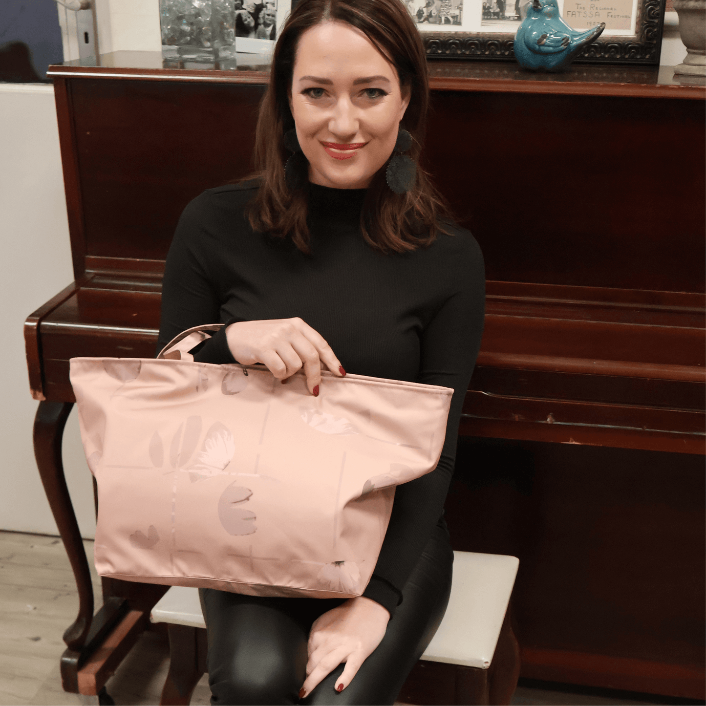 Model holding a large warm orange pink canvas shoulder tote bag from the South African Stone Meadow collection for work or travel.