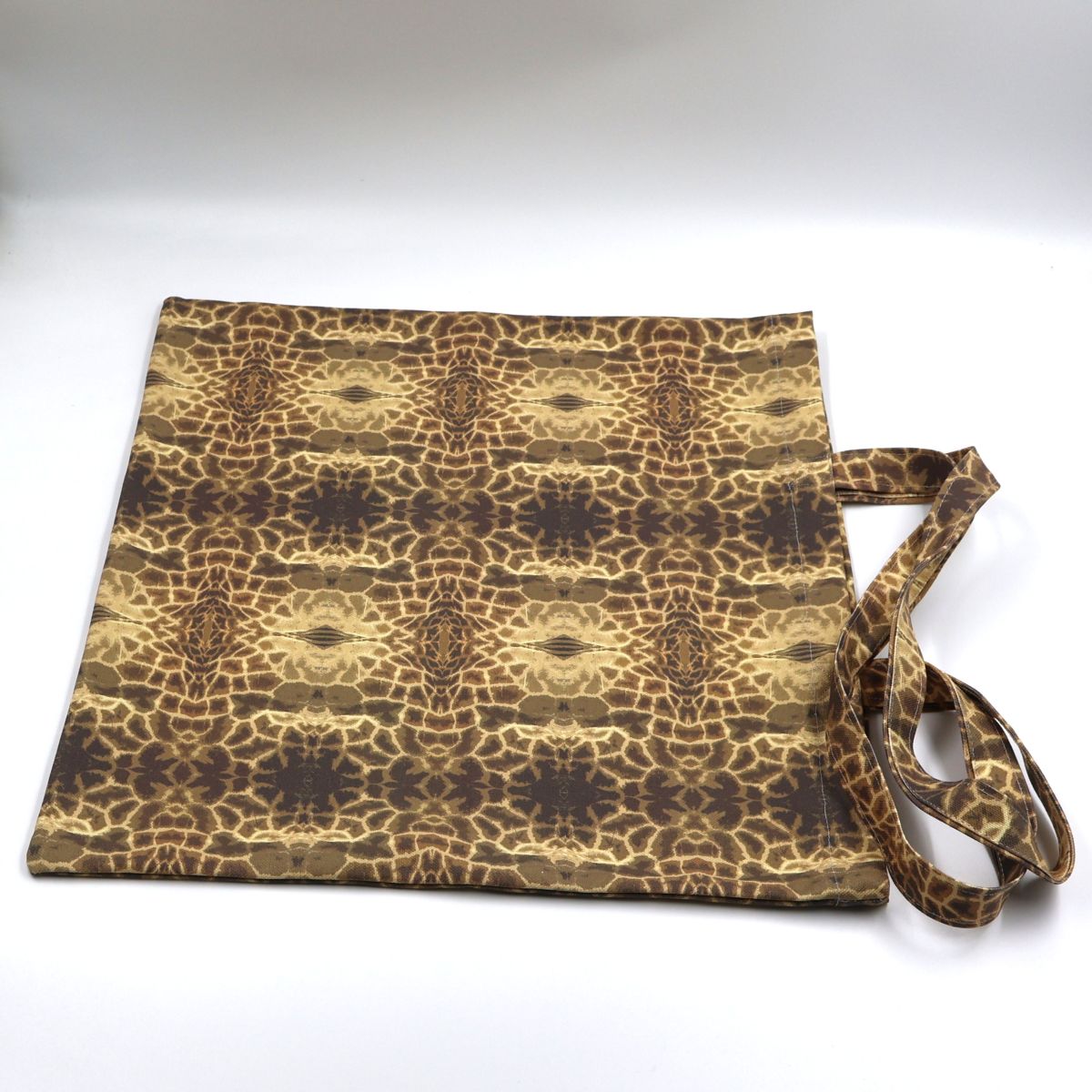 Close up view of durable stitching and premium finishes on brown canvas giraffe print bag