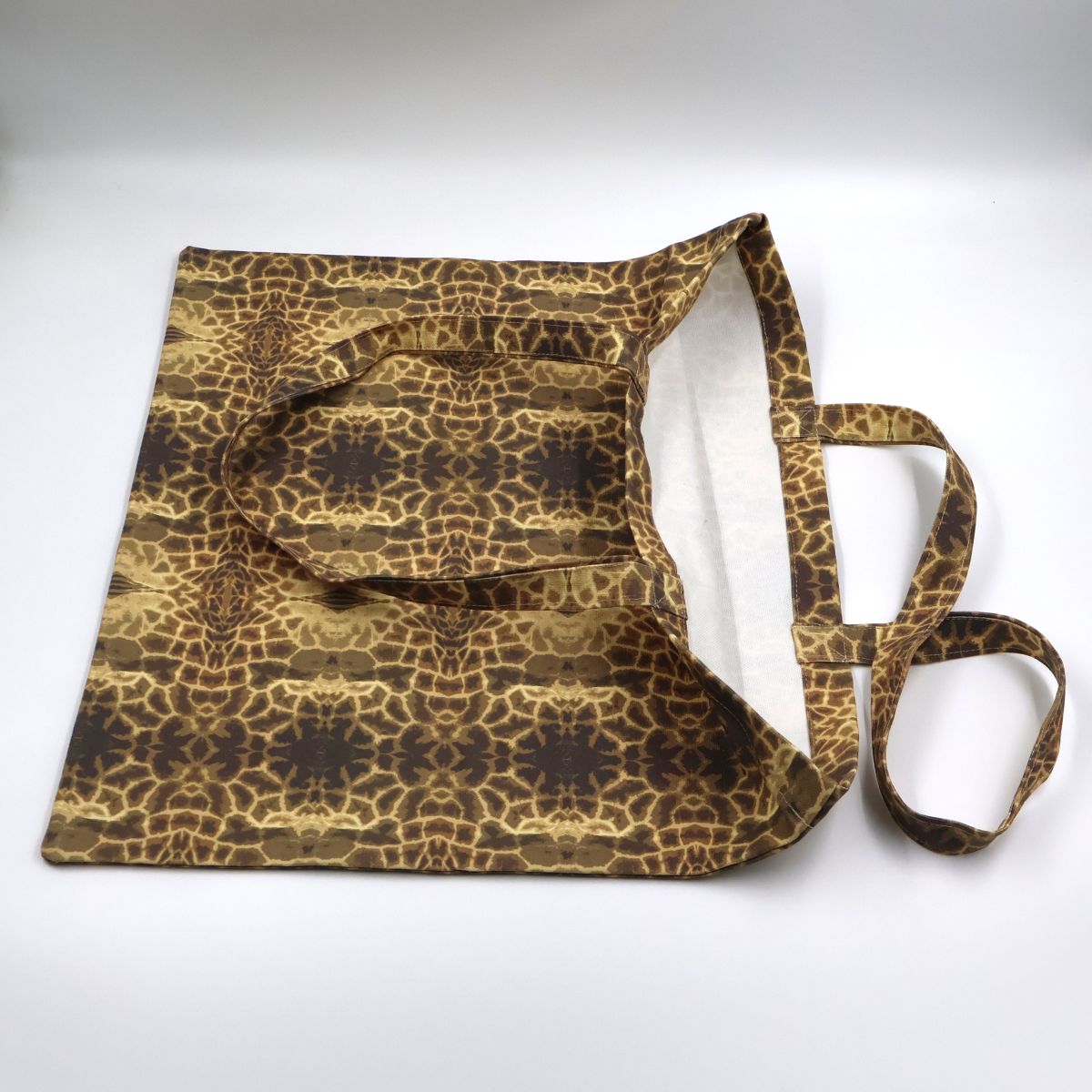Flat lay view of Letheba wildlife inspired giraffe spot canvas tote bag showing print details