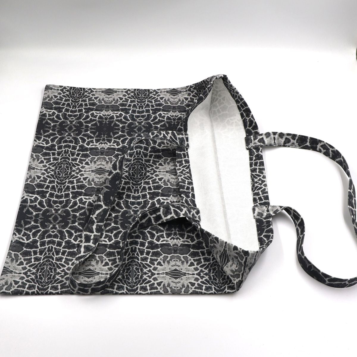 Close up view of quality stitching and finishes on charcoal cotton canvas giraffe print bag