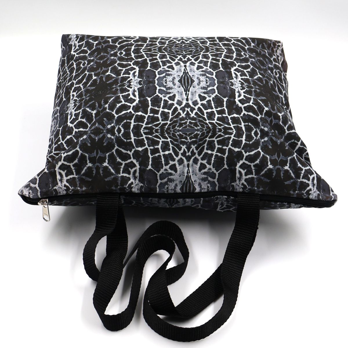 Flat lay view of Letheba water resistant dark grey giraffe spot tote showing secure zipper