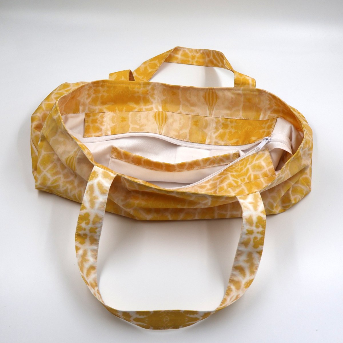 Close up view of the durable shoulder straps and premium stitching on vibrant yellow canvas bag
