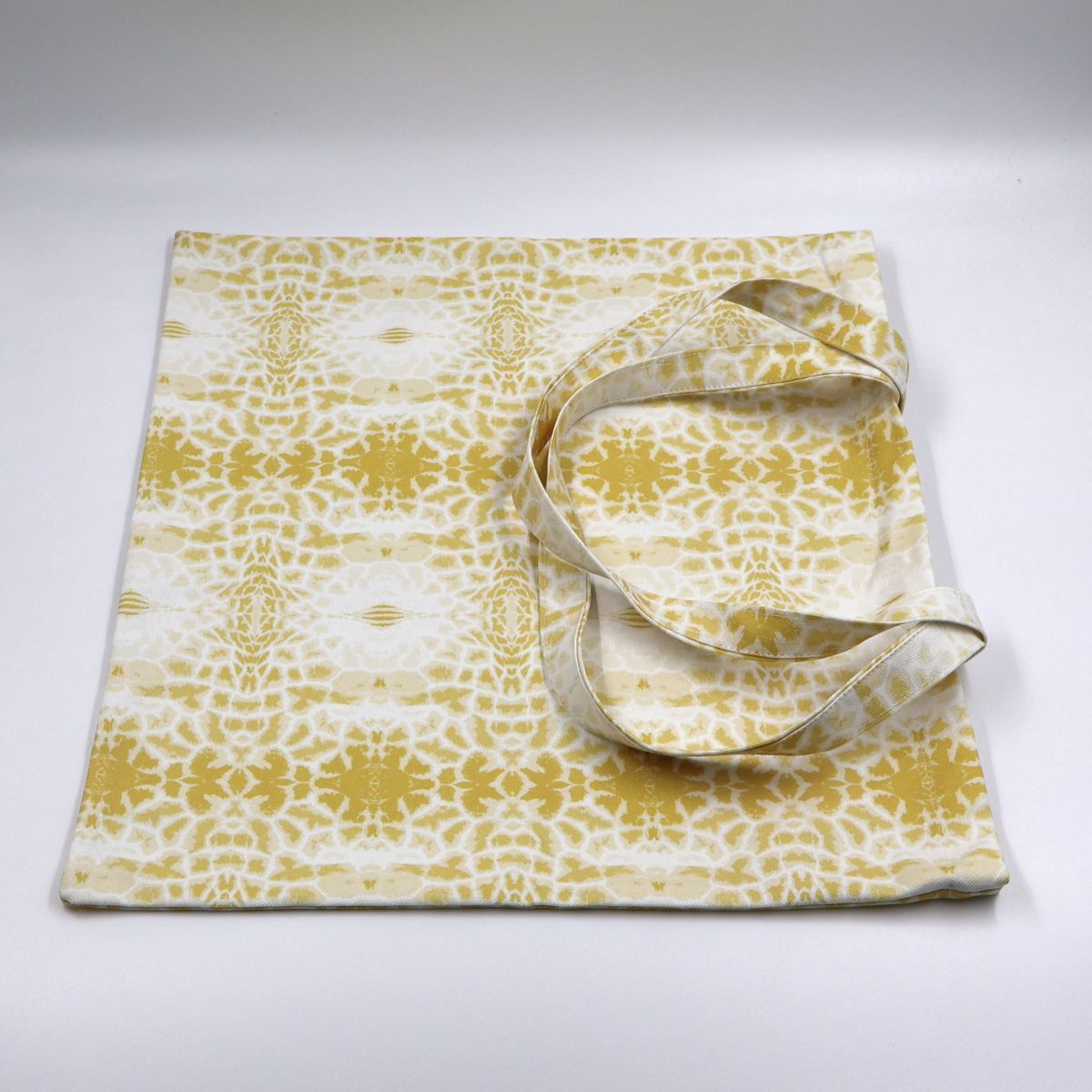 Flat lay view of Letheba contemporary yellow wildflower and giraffe spot canvas tote bag