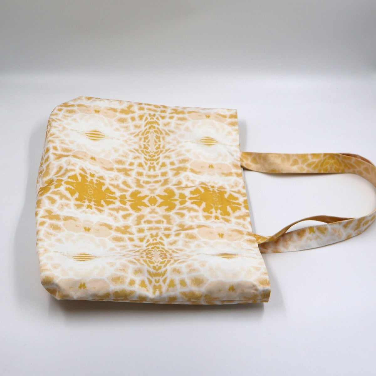 Close up view of durable shoulder straps and premium stitching on yellow polyester canvas bag