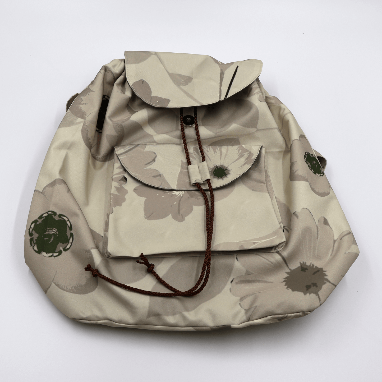 Secure drawstring and snap button closure on a water-resistant beige canvas backpack showing deep main compartment storage.