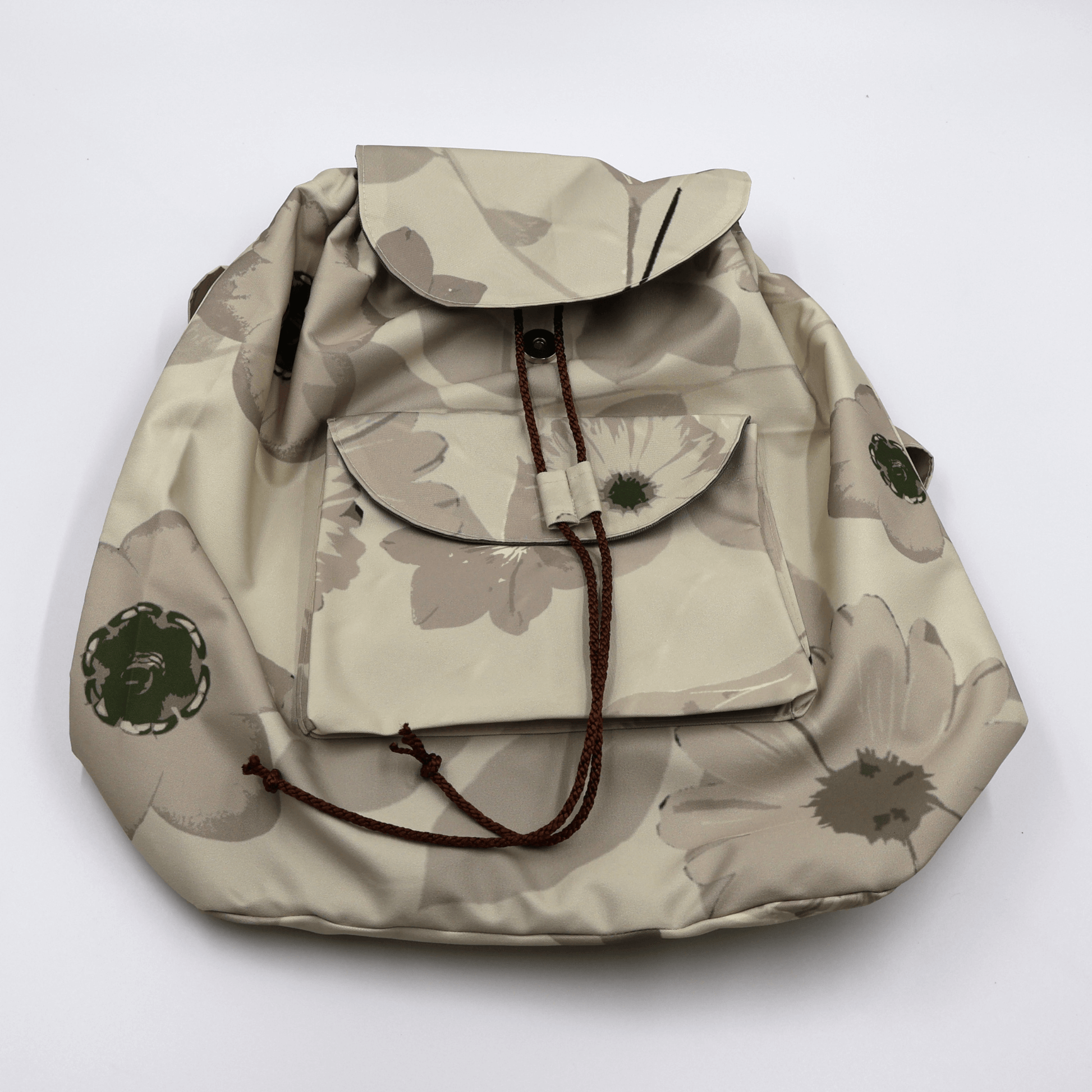 Secure drawstring and snap button closure on a water-resistant beige canvas backpack showing deep main compartment storage.