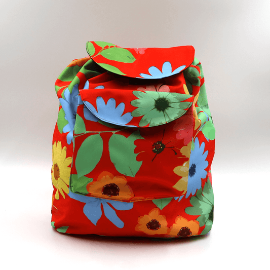 A lightweight, durable backpack with bright, colourful Daisy design on a red background. High-quality materials.