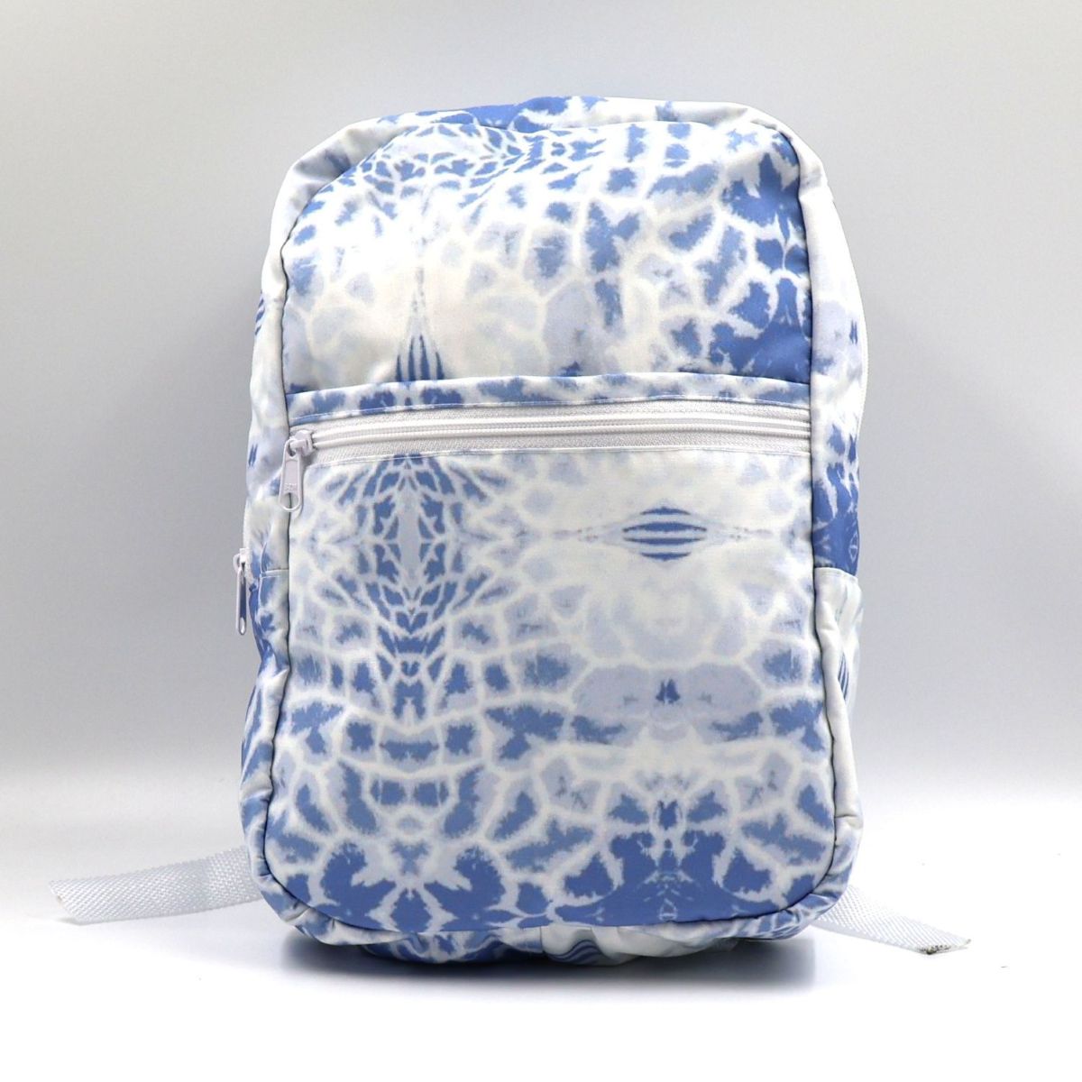 Front view of a small blue water-resistant polyester canvas backpack highlighting the giraffe print pattern and secure zippered front pocket.