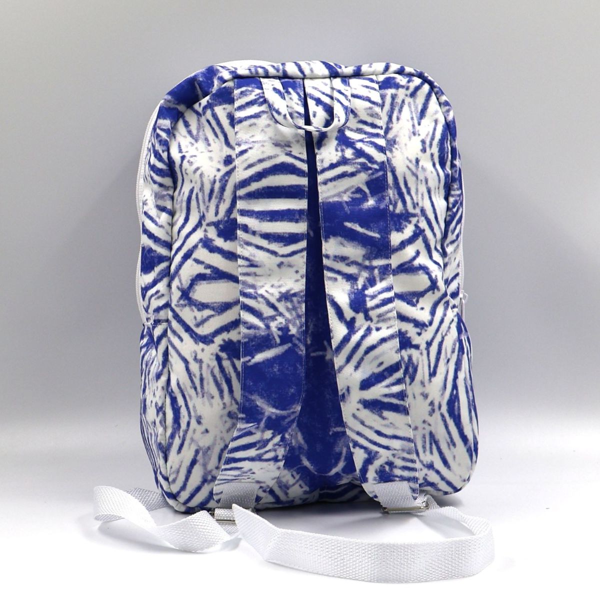 Back view of a small Blue Tshikwana nature-inspired daypack showing the wide adjustable shoulder straps and durable seam stitching.
